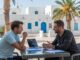 Auswandern nach Djerba, Gespräch im Freien mit beränderte weiße Häuser und Palmen, Beratung für den Neustart auf Djerba, Immobilien und Lebensqualität in Tunesien, Experten für Djerba-Auswanderung.