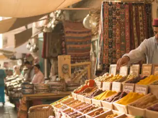 Aromatische getrocknete Gewürze auf einem Marktstand in Djerba, Tunesien, mit einem Verkäufer, der verschiedene Gewürze präsentiert und Kunden, die die Vielfalt der Aromen entdecken.