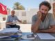 Verzweifelter Mann bei der Auswanderung nach Djerba, Tunisische Flagge im Hintergrund, Dokumente auf dem Tisch, Symbol für die Herausforderungen beim Umzug nach Djerba.